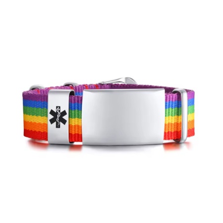 BeSafeCharm regenboog medische armband met QR-plaatje, liggend op linnen stof met houten achtergrond.