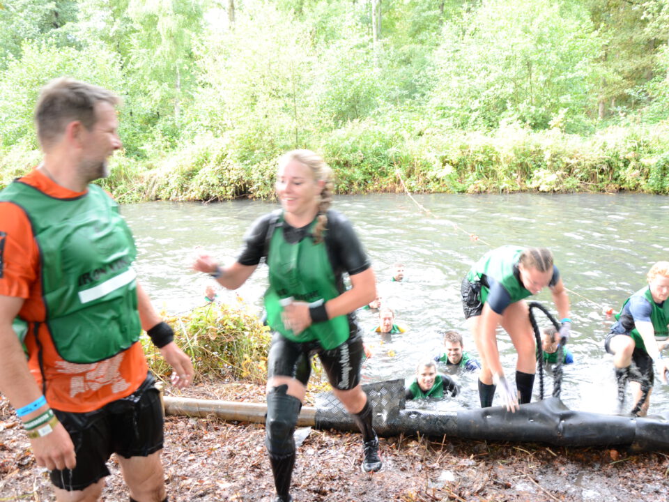 Patricia tijdens de Iron Viking met BeSafeCharm ketting en armband, volledig bedekt in modder na 42 km obstacle run.